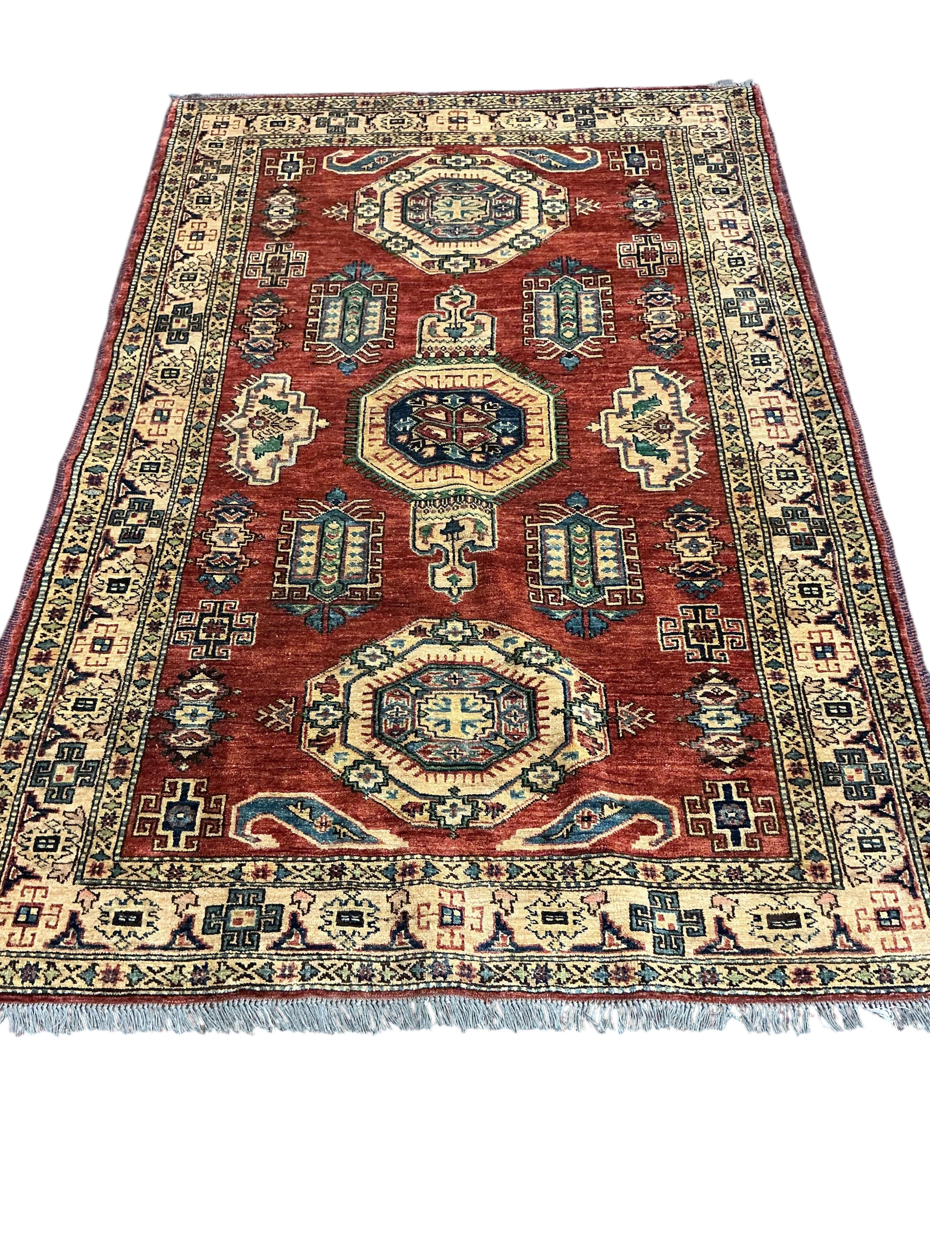 A Caucasian design brick red ground rug, 200cm x 140cm
